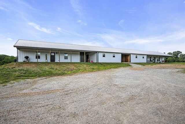 view of front of home with metal roof and dirt driveway