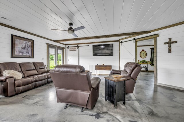 living room featuring finished concrete flooring, a barn door, and visible vents