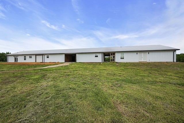 rear view of property with an outbuilding, a yard, and a garage