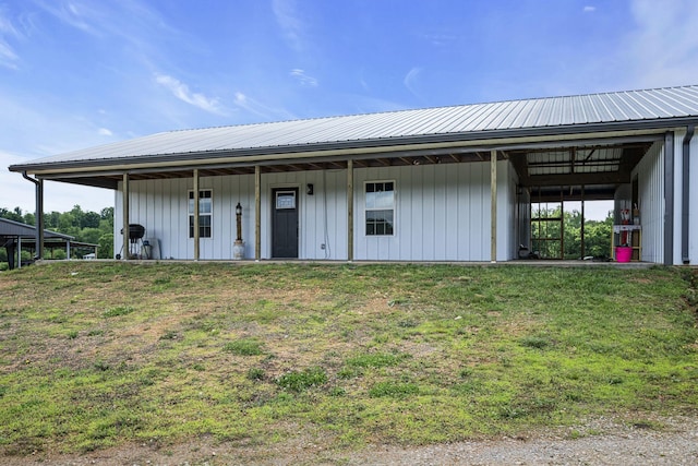 view of front of home with metal roof and a front lawn