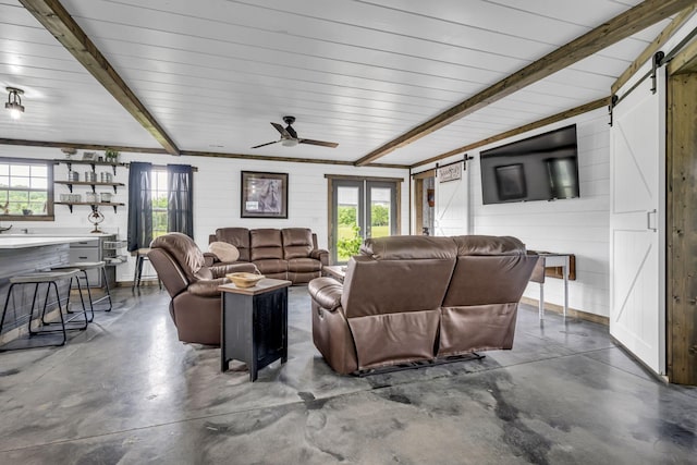 living area with a healthy amount of sunlight, finished concrete flooring, and a barn door