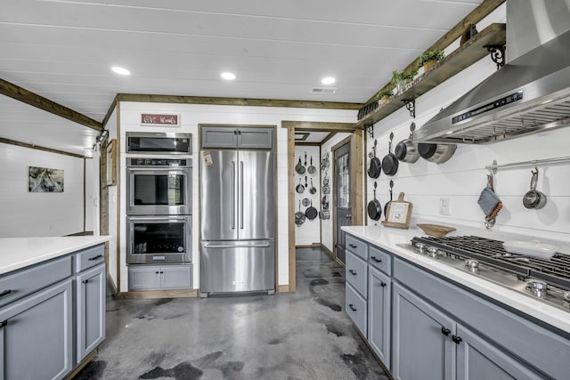 kitchen with range hood, appliances with stainless steel finishes, gray cabinets, and concrete flooring