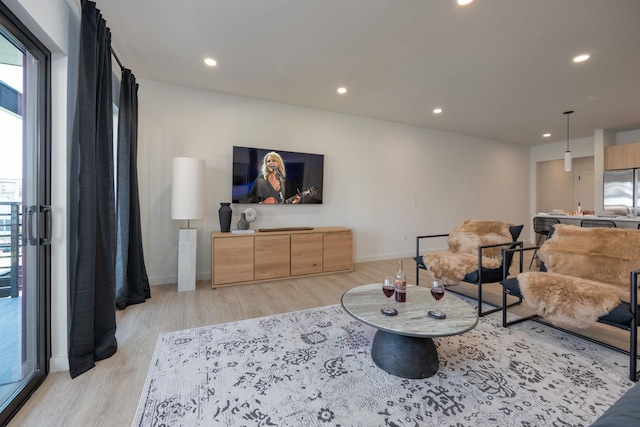 living room with baseboards, light wood finished floors, and recessed lighting