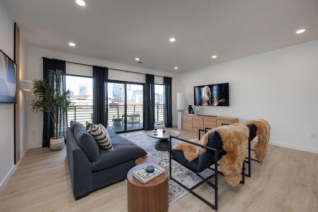 living room featuring recessed lighting, baseboards, and light wood finished floors