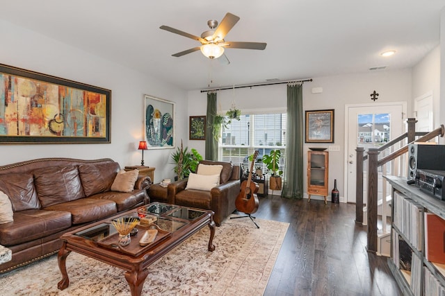 living area with stairs, visible vents, dark wood finished floors, and a ceiling fan