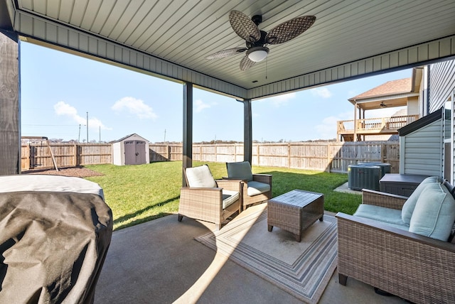 view of patio featuring ceiling fan, a fenced backyard, an outbuilding, a shed, and an outdoor living space