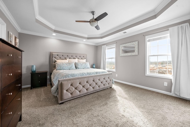 carpeted bedroom featuring ornamental molding, a raised ceiling, visible vents, and baseboards