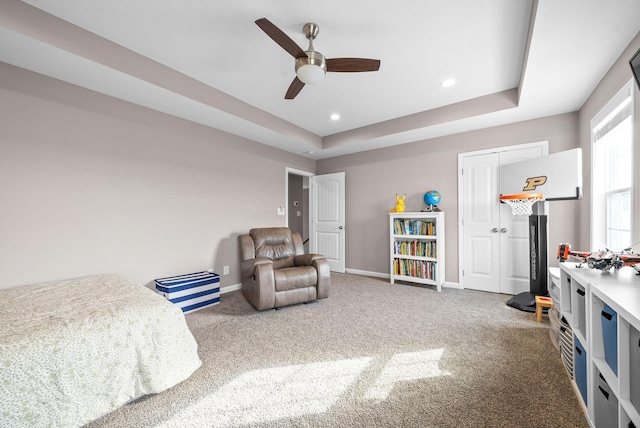 bedroom with a tray ceiling, recessed lighting, a ceiling fan, carpet flooring, and baseboards