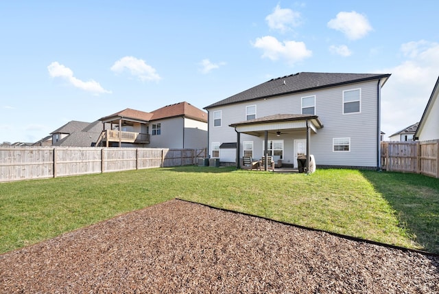 back of house featuring a ceiling fan, a fenced backyard, a residential view, a yard, and a patio area