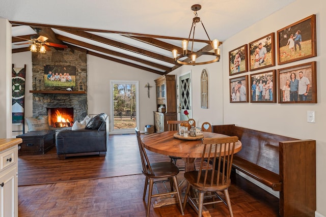 dining space featuring lofted ceiling with beams, ceiling fan with notable chandelier, a fireplace, and parquet flooring