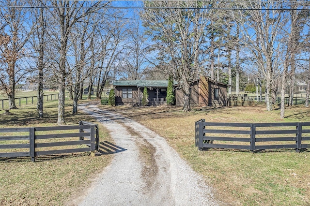 view of front of home with driveway, fence, and a front lawn