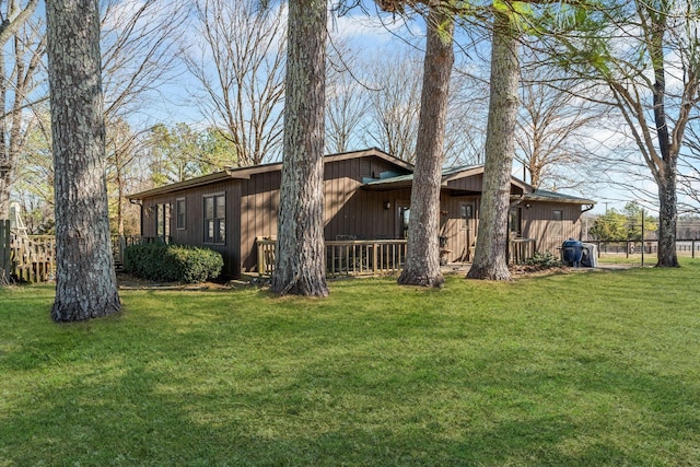 view of side of home featuring fence and a yard