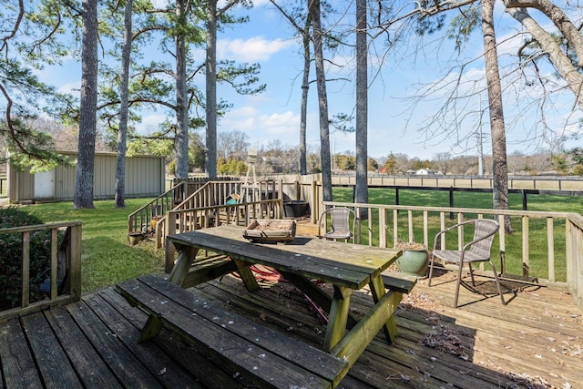 wooden terrace featuring a fenced backyard, a yard, and an outdoor structure