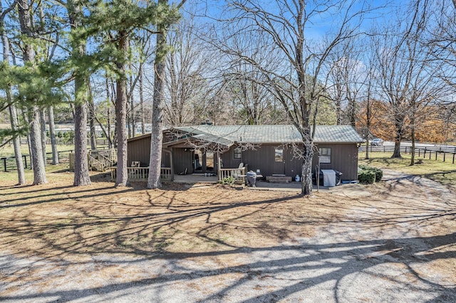 view of front of property featuring fence and metal roof