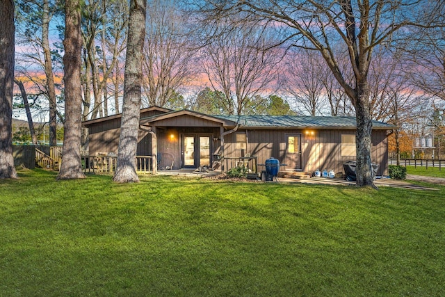 back of house featuring a yard, metal roof, and french doors