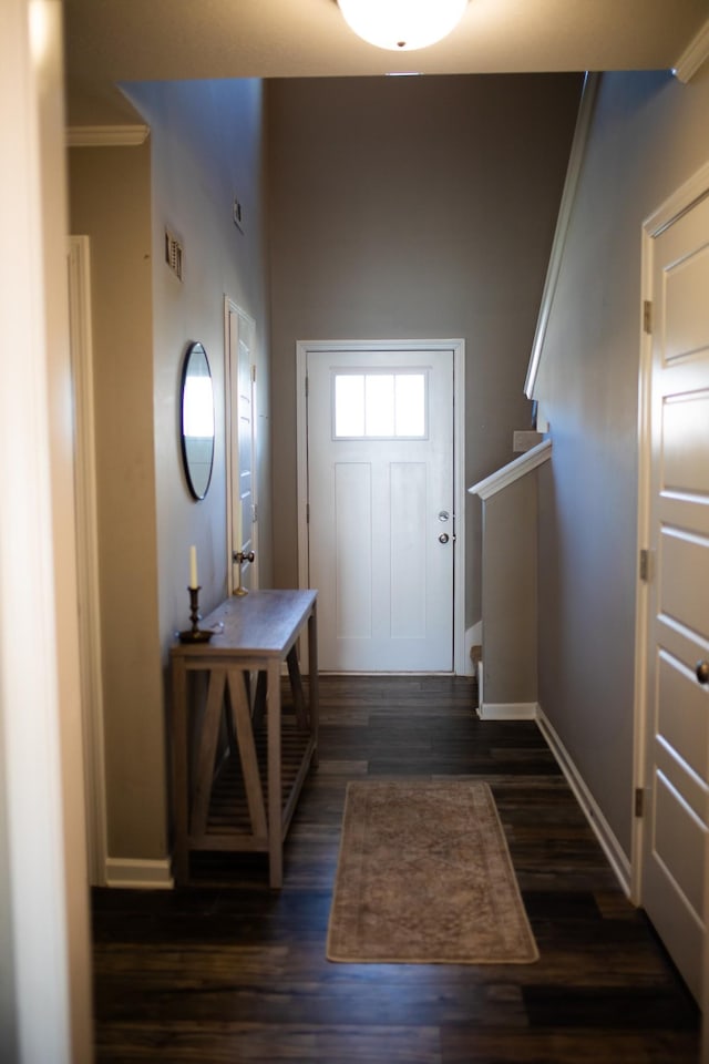 foyer entrance with dark wood finished floors, visible vents, stairway, ornamental molding, and baseboards