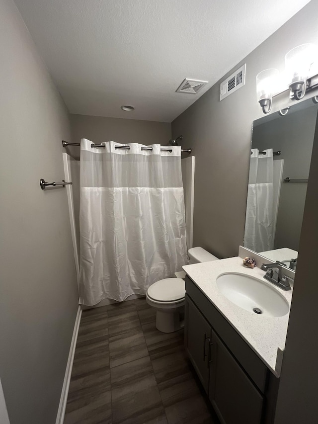 bathroom featuring a shower with curtain, visible vents, vanity, and toilet