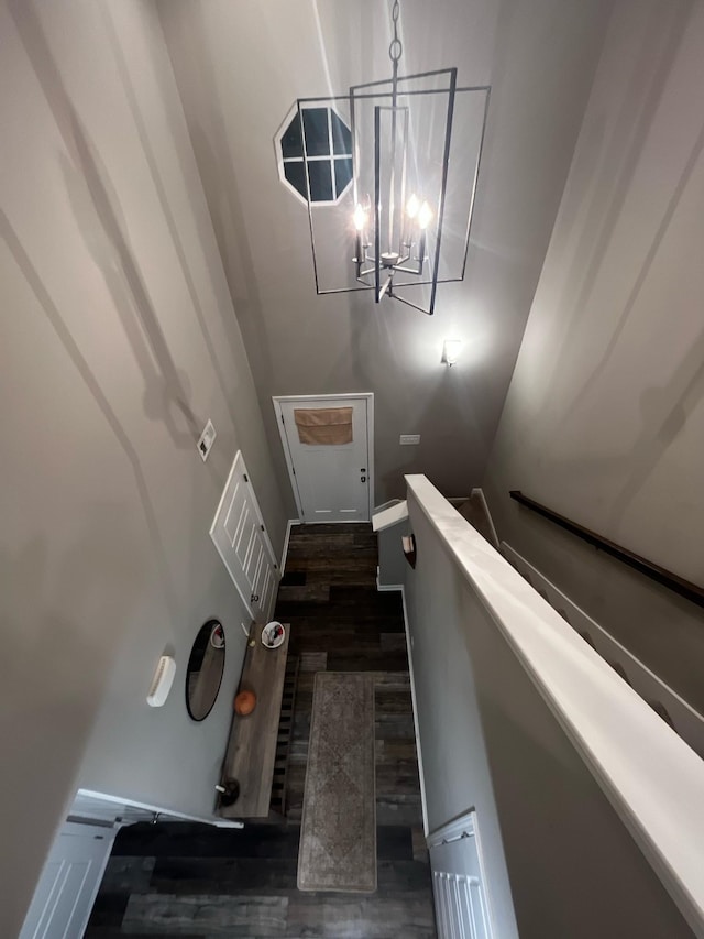 staircase featuring a chandelier and wood finished floors