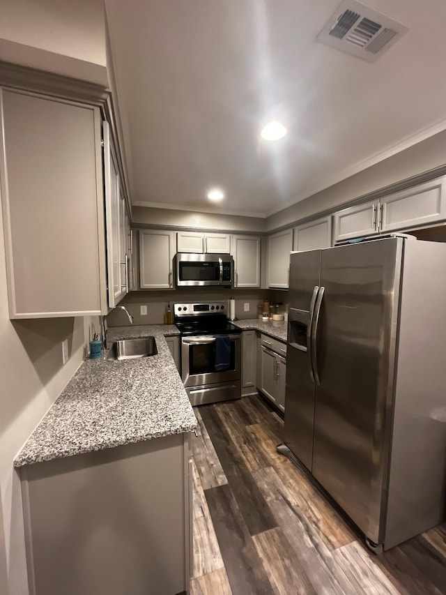 kitchen featuring dark wood-style floors, stainless steel appliances, visible vents, gray cabinetry, and a sink