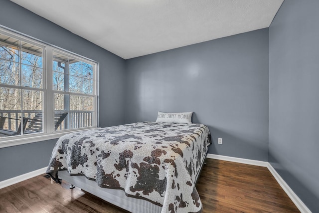 bedroom with wood finished floors and baseboards