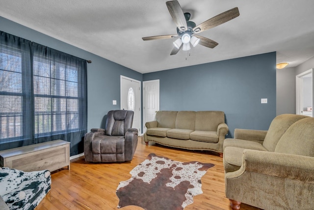 living room with a ceiling fan and wood finished floors