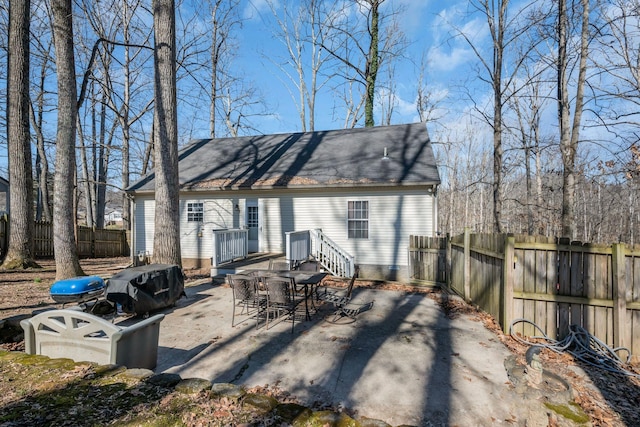 back of property with fence, outdoor dining area, and a patio