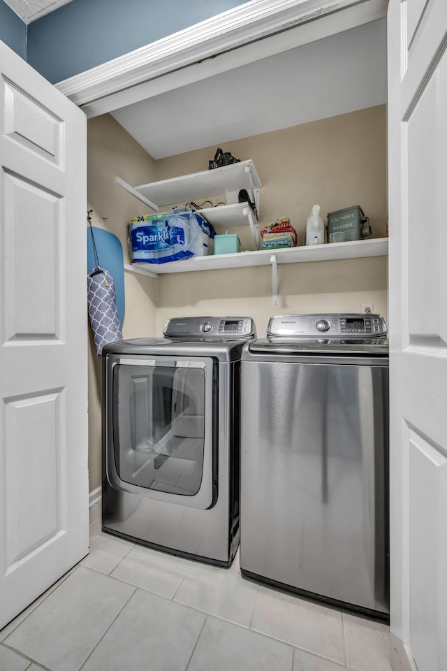 washroom featuring light tile patterned floors, laundry area, and washing machine and dryer