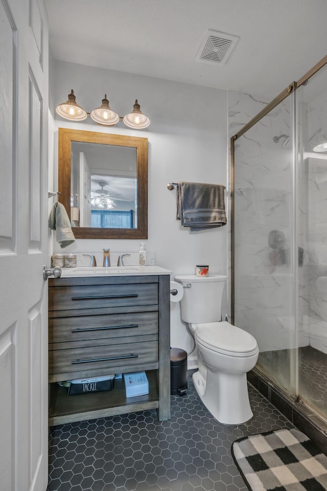 full bathroom with toilet, a marble finish shower, visible vents, and vanity