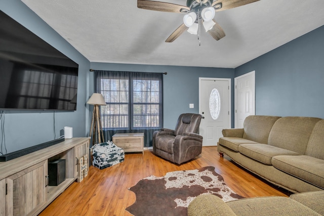 living room with ceiling fan and light wood-style flooring