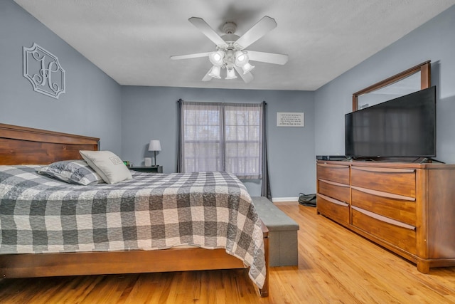 bedroom featuring baseboards, a ceiling fan, and light wood-style floors