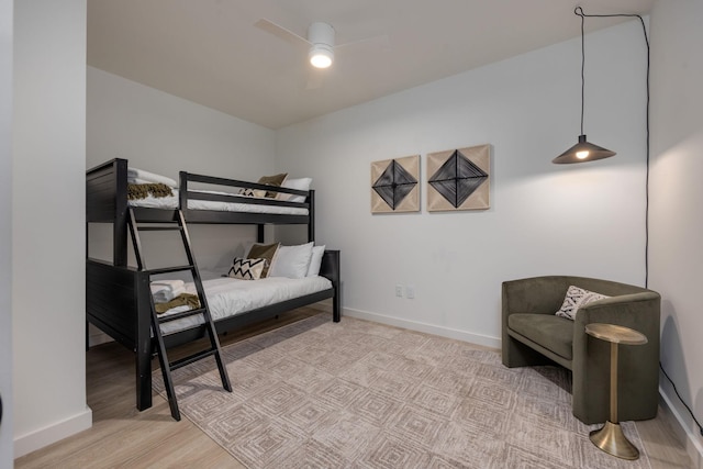 bedroom featuring a ceiling fan, baseboards, and wood finished floors