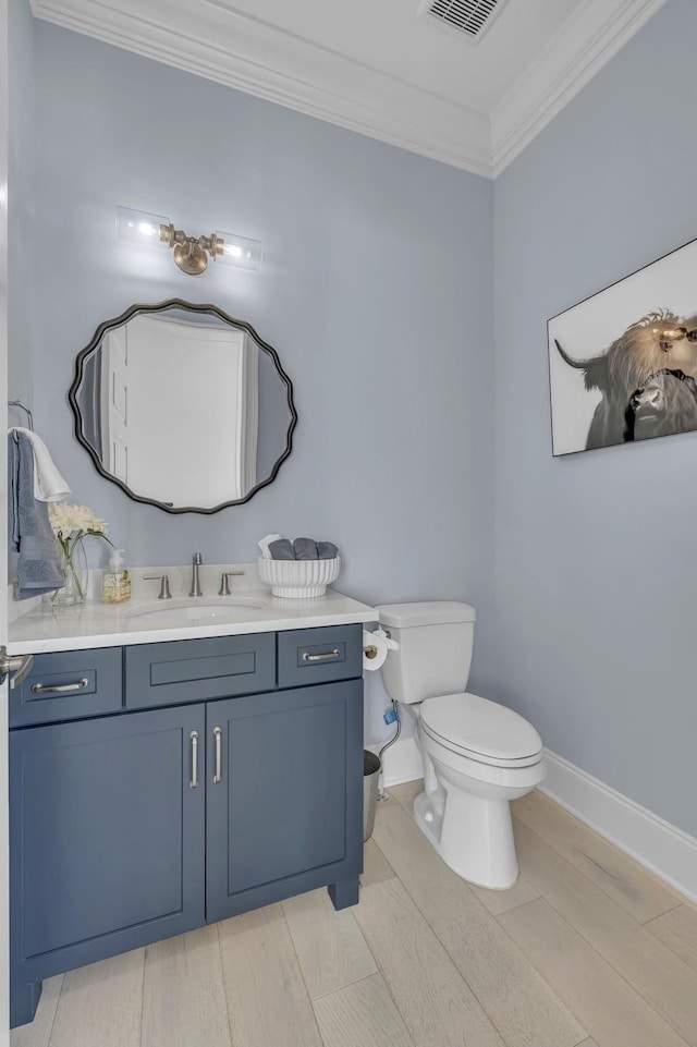 bathroom featuring baseboards, visible vents, toilet, ornamental molding, and vanity