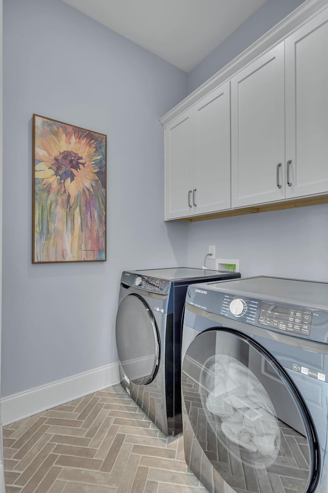 laundry area with cabinet space, baseboards, and washer and clothes dryer