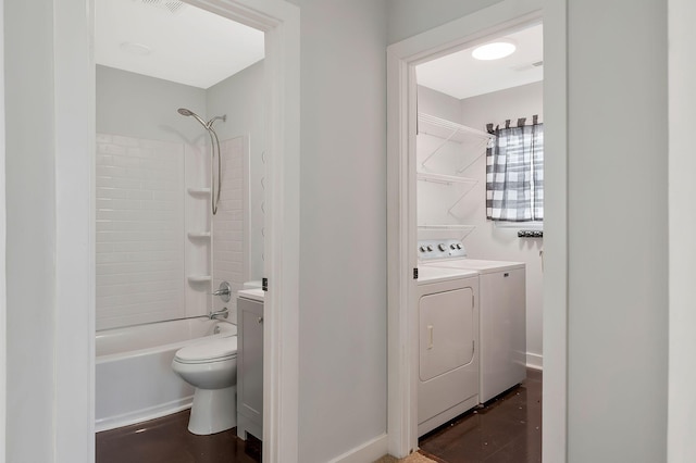 full bathroom with shower / bathtub combination, washing machine and dryer, toilet, visible vents, and baseboards