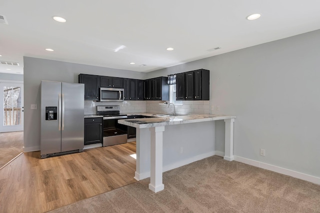 kitchen with light countertops, visible vents, decorative backsplash, appliances with stainless steel finishes, and dark cabinetry