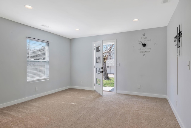 spare room featuring light carpet, recessed lighting, and baseboards