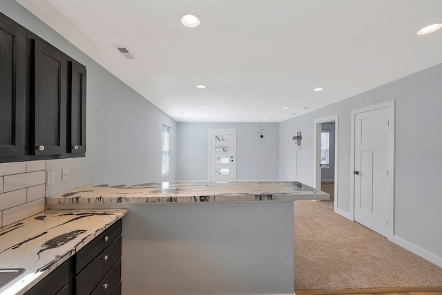 kitchen with light stone counters, recessed lighting, light colored carpet, a peninsula, and visible vents