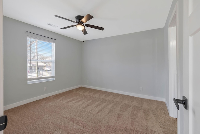 spare room featuring light carpet, baseboards, visible vents, and ceiling fan