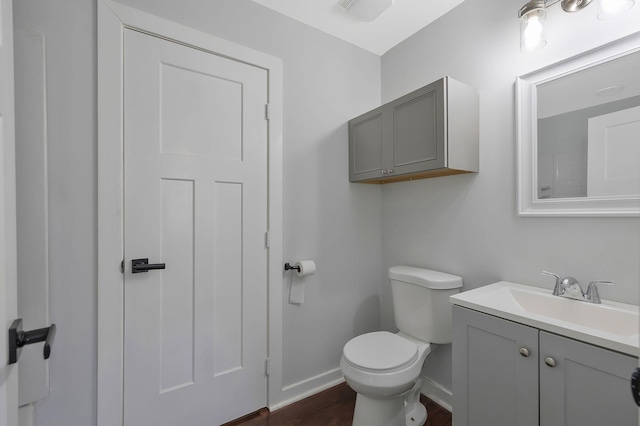 bathroom featuring wood finished floors, vanity, toilet, and baseboards