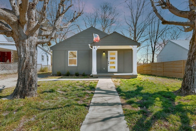 bungalow-style house with fence and a front yard