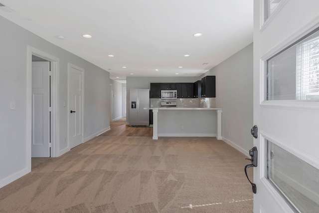 unfurnished living room with light carpet, baseboards, and recessed lighting