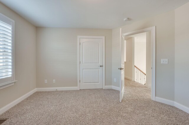 carpeted empty room featuring visible vents and baseboards