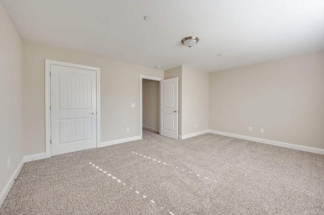 unfurnished bedroom with carpet flooring and baseboards