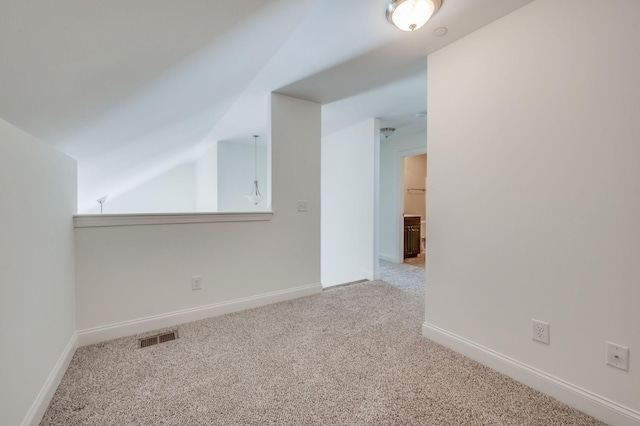 additional living space with vaulted ceiling, carpet, visible vents, and baseboards