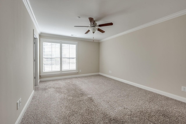 carpeted spare room featuring ornamental molding, a ceiling fan, and baseboards