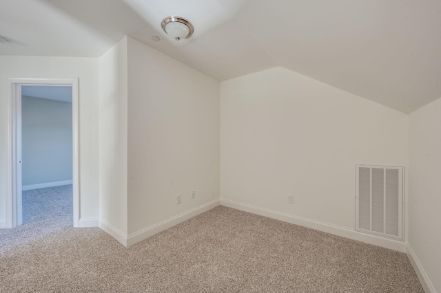 bonus room with baseboards, visible vents, vaulted ceiling, and light colored carpet