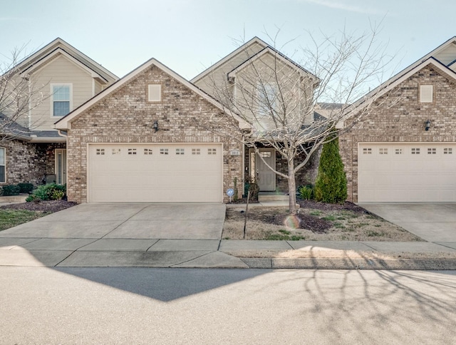 view of front of home featuring a garage, concrete driveway, and brick siding