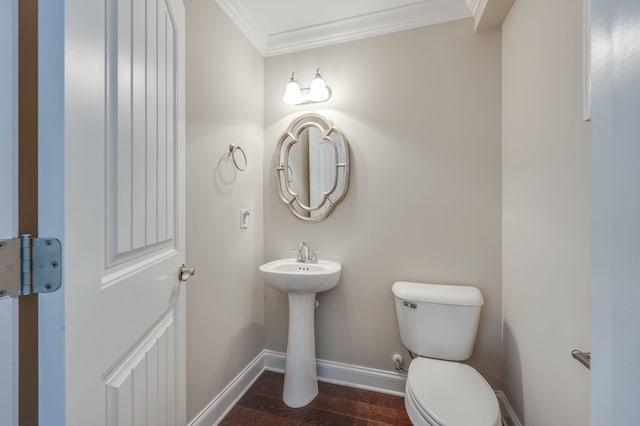 half bath with crown molding, toilet, baseboards, and wood finished floors