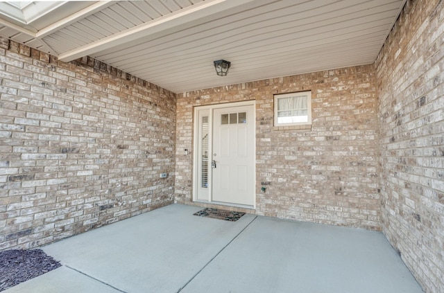 view of exterior entry featuring brick siding