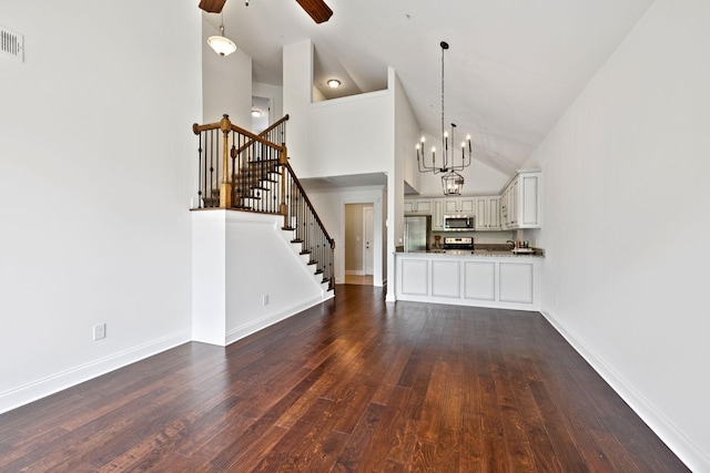 1012 Irish Way, Spring Hill, TN 37174 - unfurnished living room featuring high vaulted ceiling, dark wood-type flooring, ceiling fan, a chandelier, and stairs